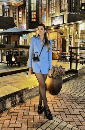 a woman in a blue blazer and black stockings