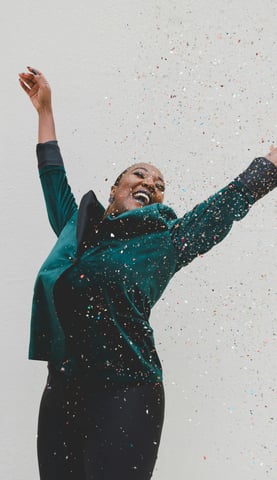 frau springt vor Freude konfetti