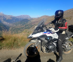 a man in a black jacket and helmet on a motorcycle