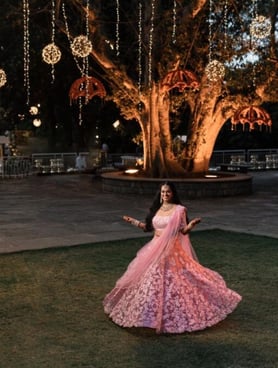 a woman in a pink dress and a tree with lights