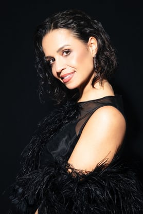a woman in a black dress with a black feathered jacket