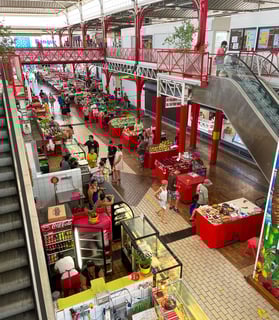 Bustling local market in Tahiti, French Polynesia, with vibrant stalls of fresh fruits, vegetables, and handmade goods.