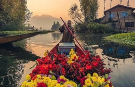 a man in a boat with flowers in the water