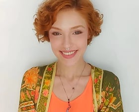 Sabrina Tibursky com os braços cruzados e sorriso acolhedor