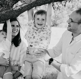 Enfants jouant à se suspendre à un arbre avec l’aide de leurs parents – séance photo de famille Gard