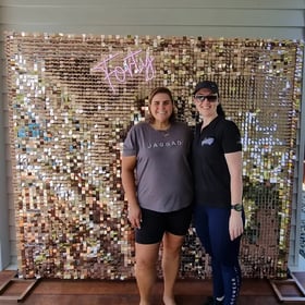 Linell and Carly in front of the rose gold shimmer wall and Forty neon sign in Brisbane.