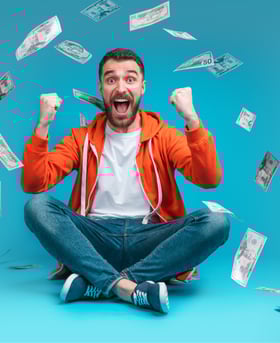 a man sitting on a floor with money bills and money