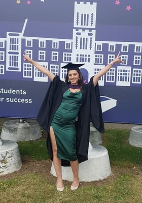 a woman in a graduation gown and a graduation cap