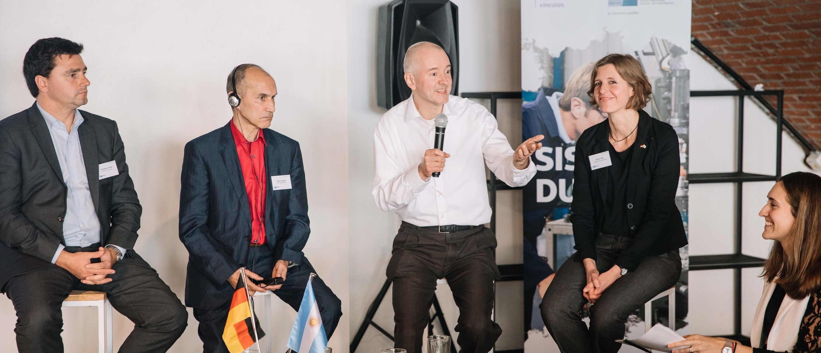 Jörg Grube mit weißem Hemd und Mikrophon in der Hand während einer Gesprächsrunde bei der IHK