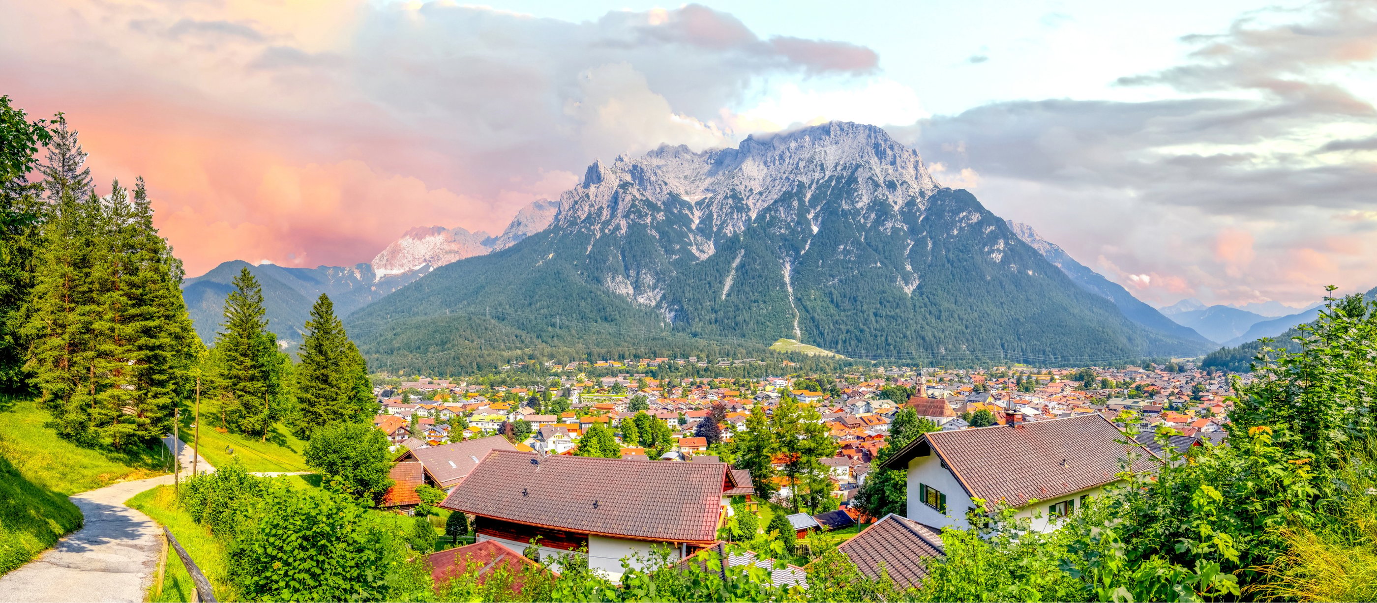 Scenic landscape view of Mittenwald village nestled below the Karwendel mountains in the Bavarian Alps.