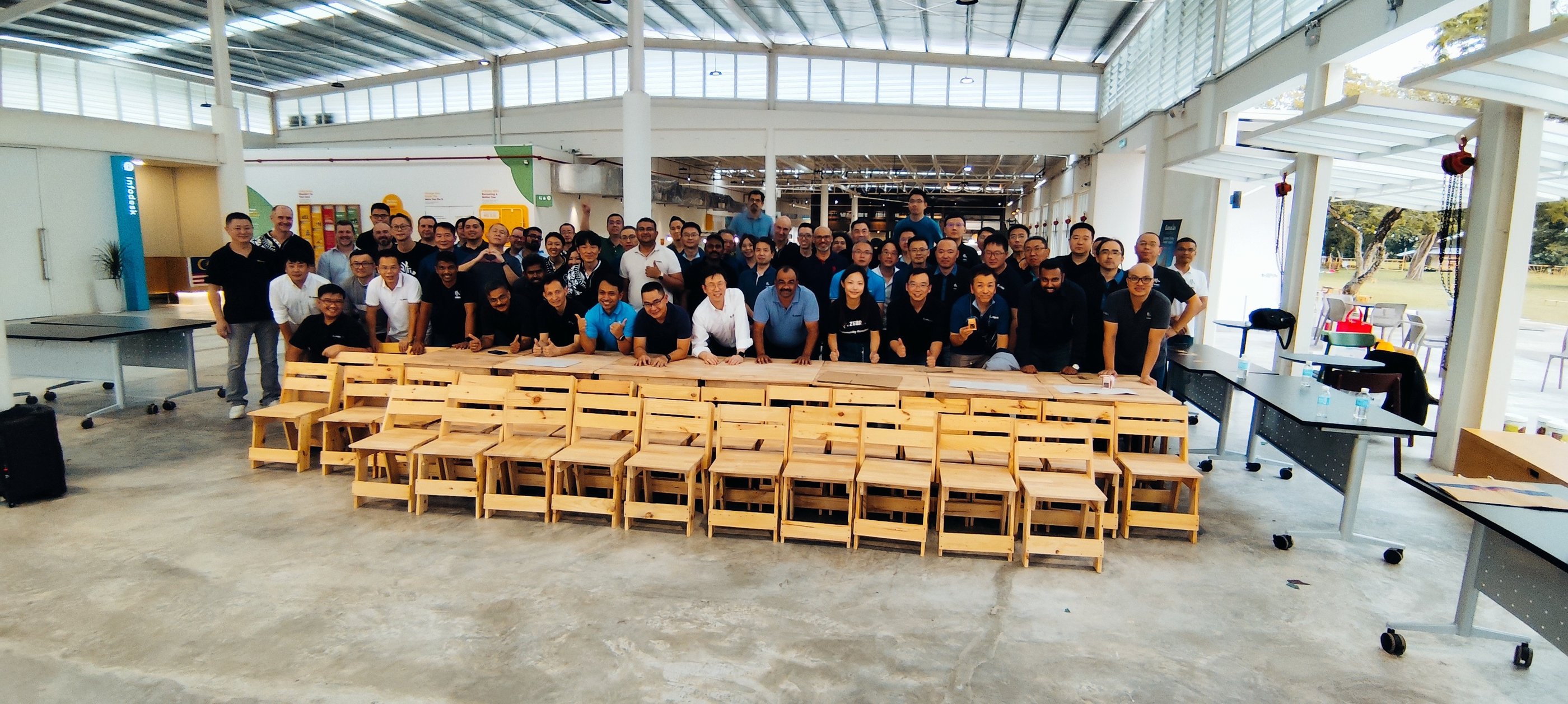 Participants posing for photos after completed making classroom chairs and tables