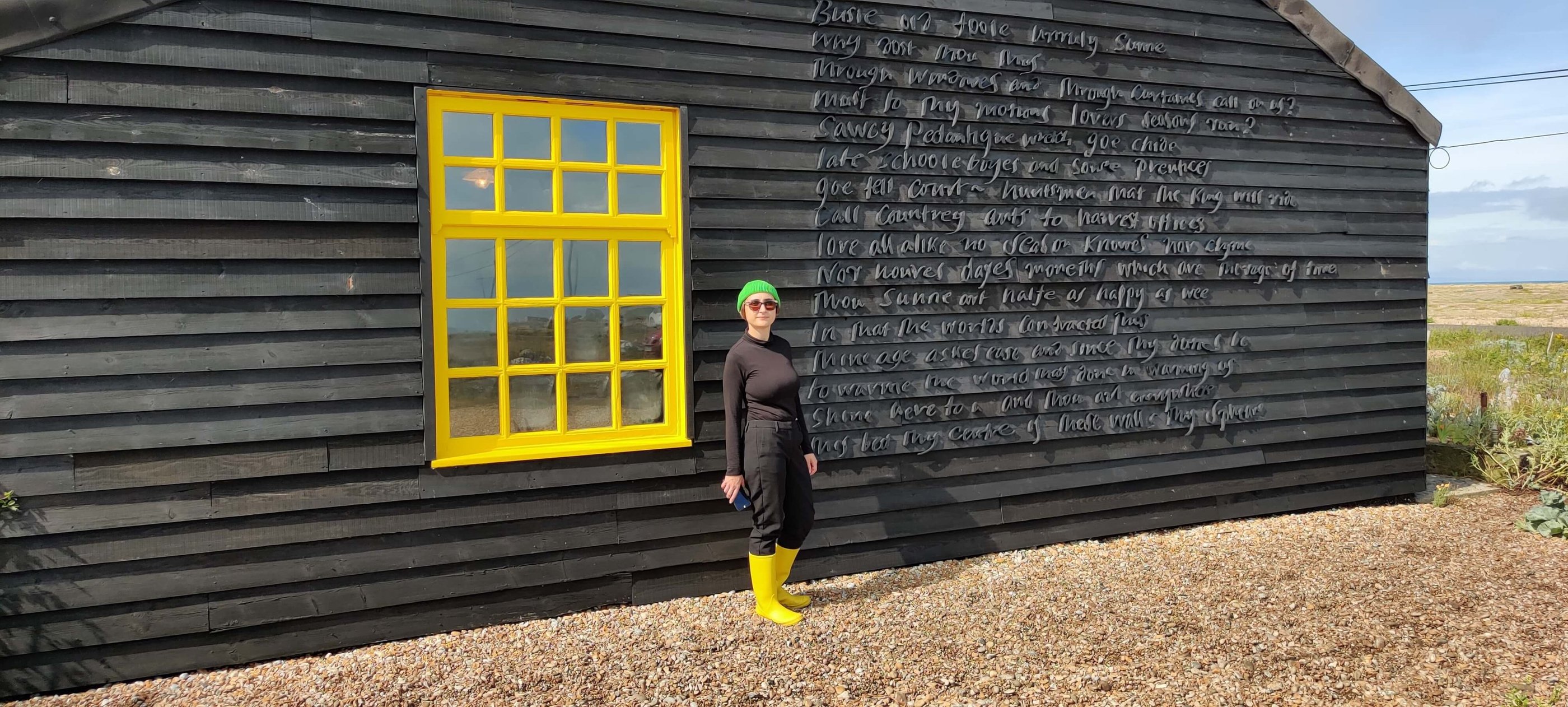 photo of Micha wearing bright yellow welly boots next to yellow window