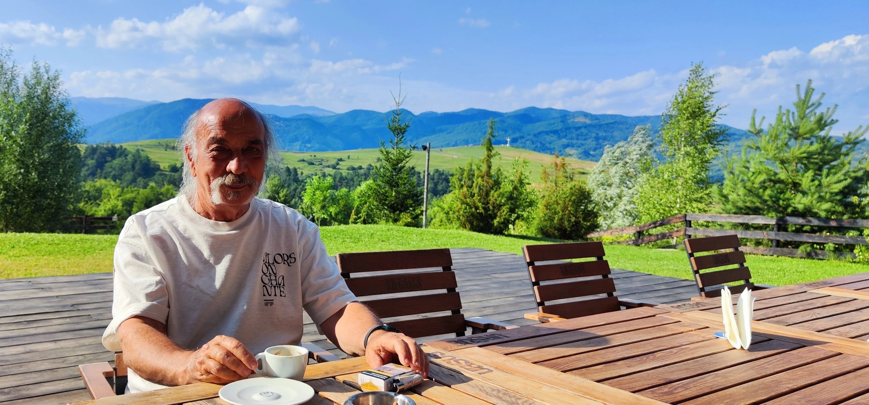 a man sitting at a table with a cup of coffee