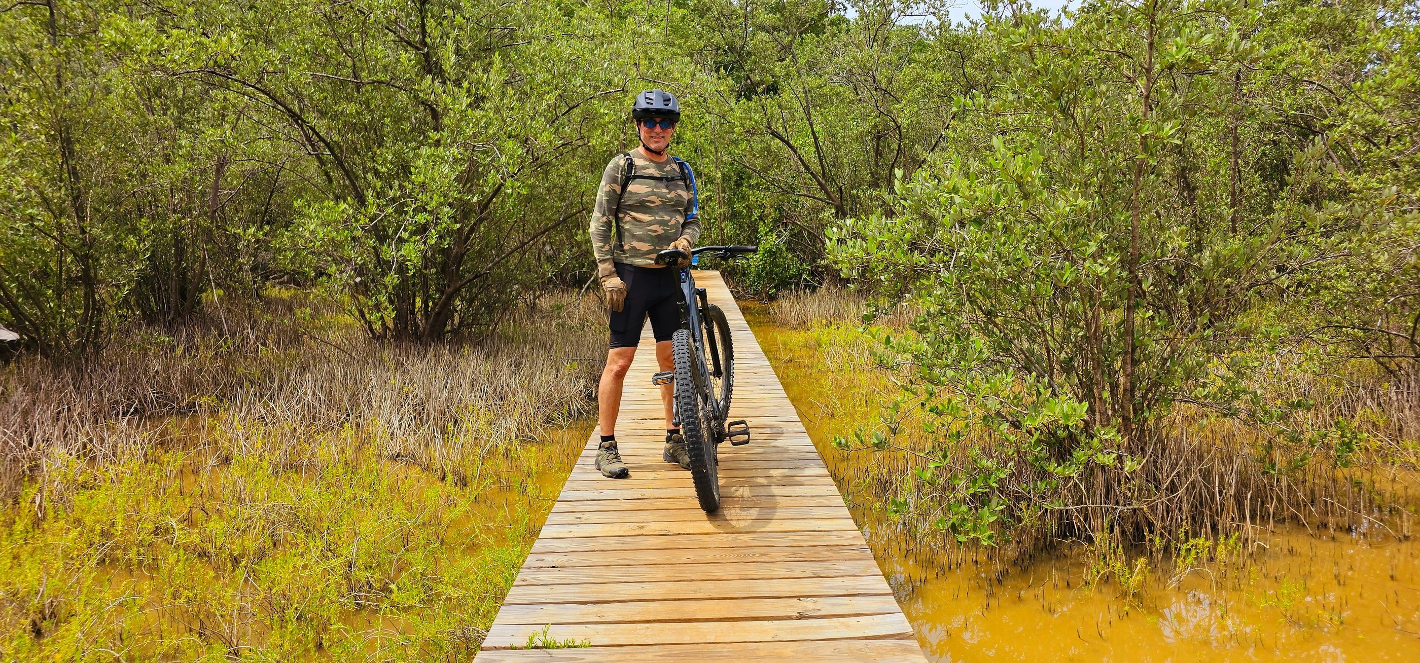 a man riding a bike on a wooden bridge