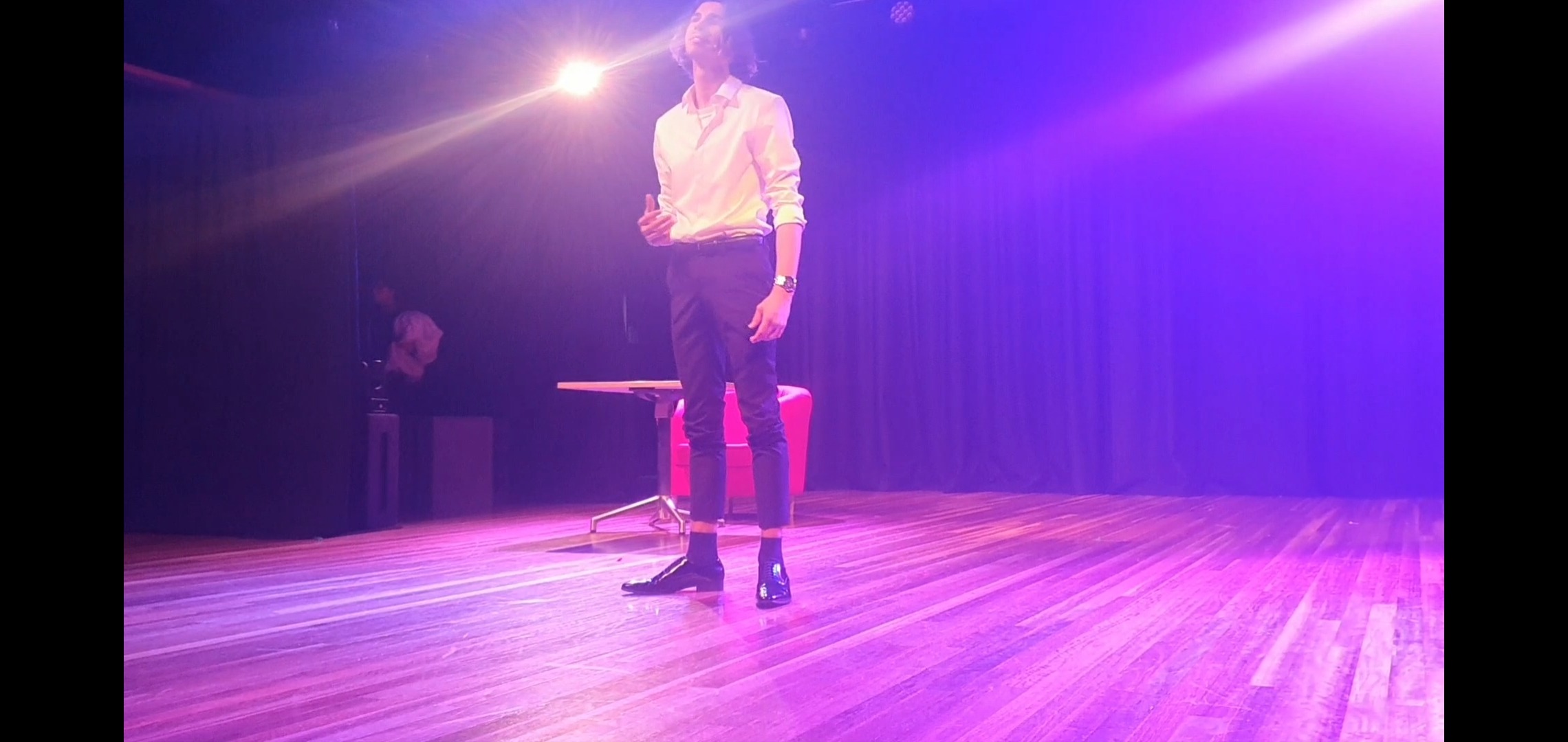 a man standing on a stool with a microphone