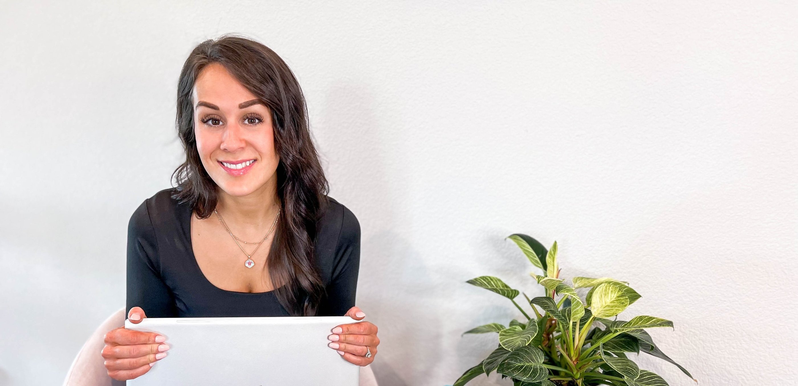 Woman holding laptop and smiling