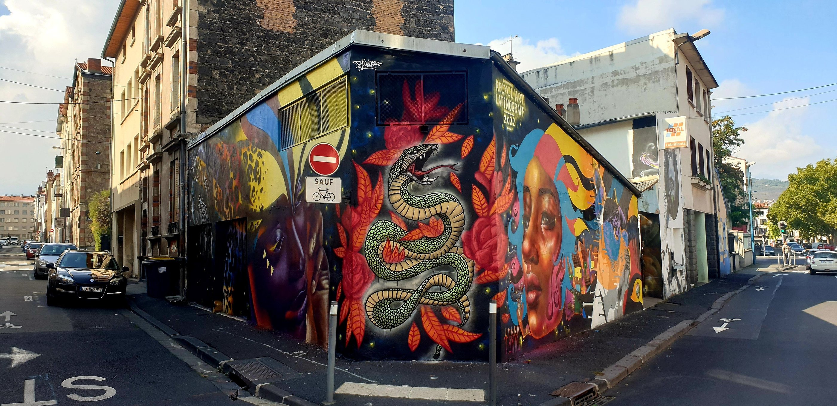 une fresque street art avec un serpent deux portrait de femmes un jaguar et un chien