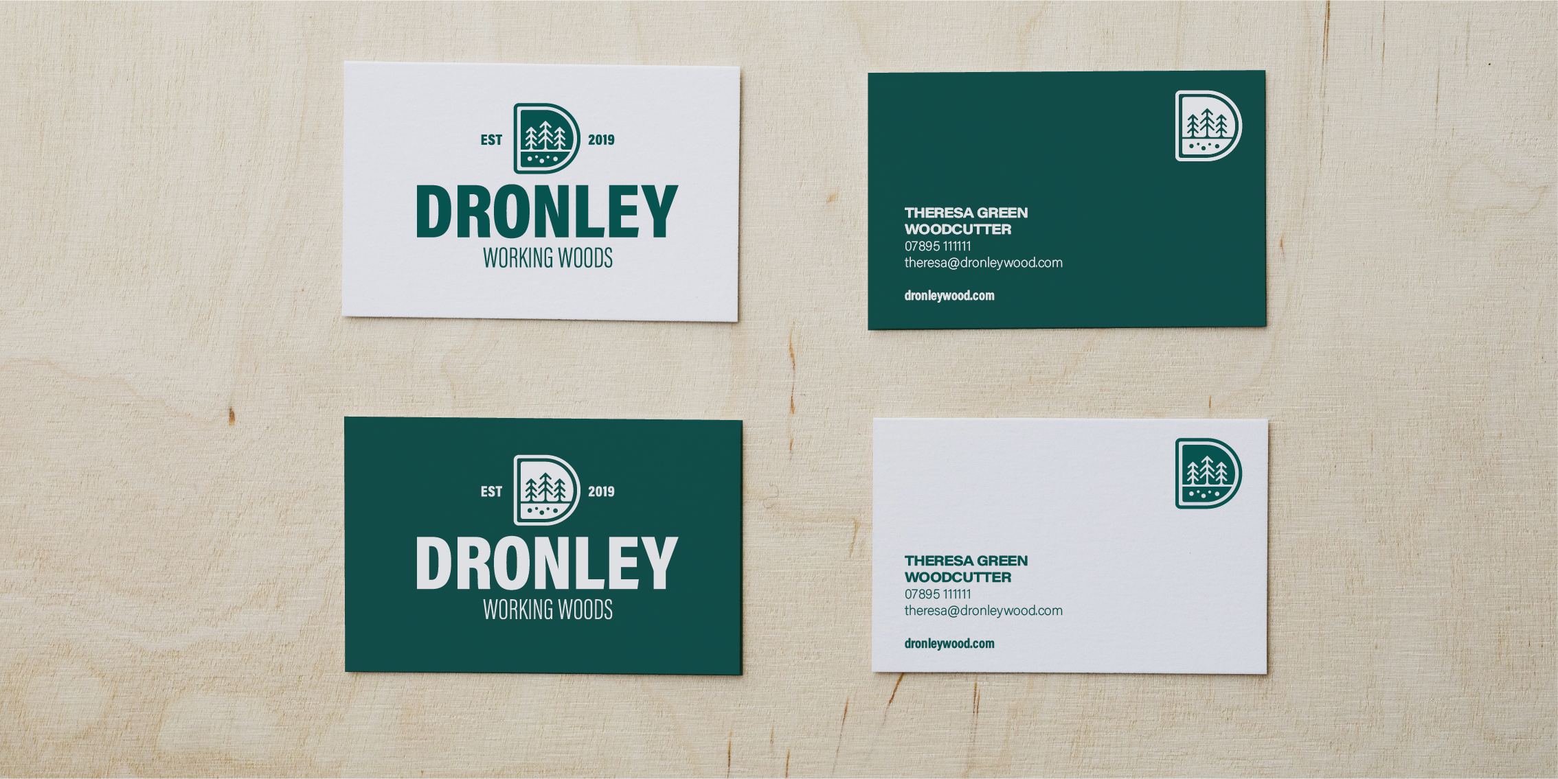 Custom woodcutter business cards for Dronley Working Woods featuring forest-themed branding on light wood.