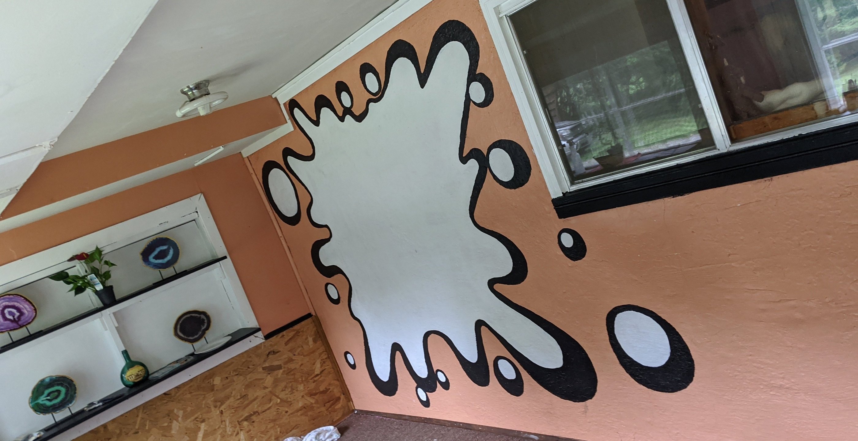 a room with a wall mural of a large splat