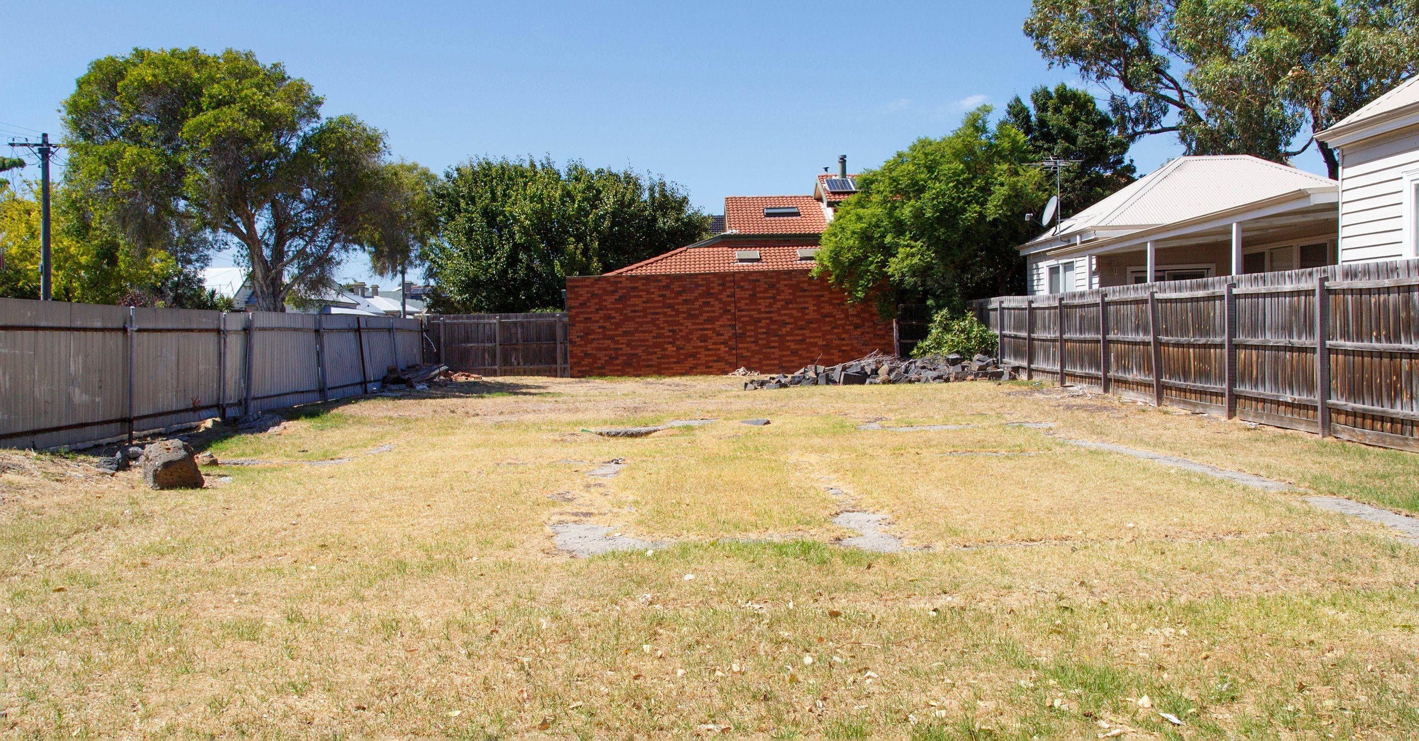 Dry yard with wooden fence and shed