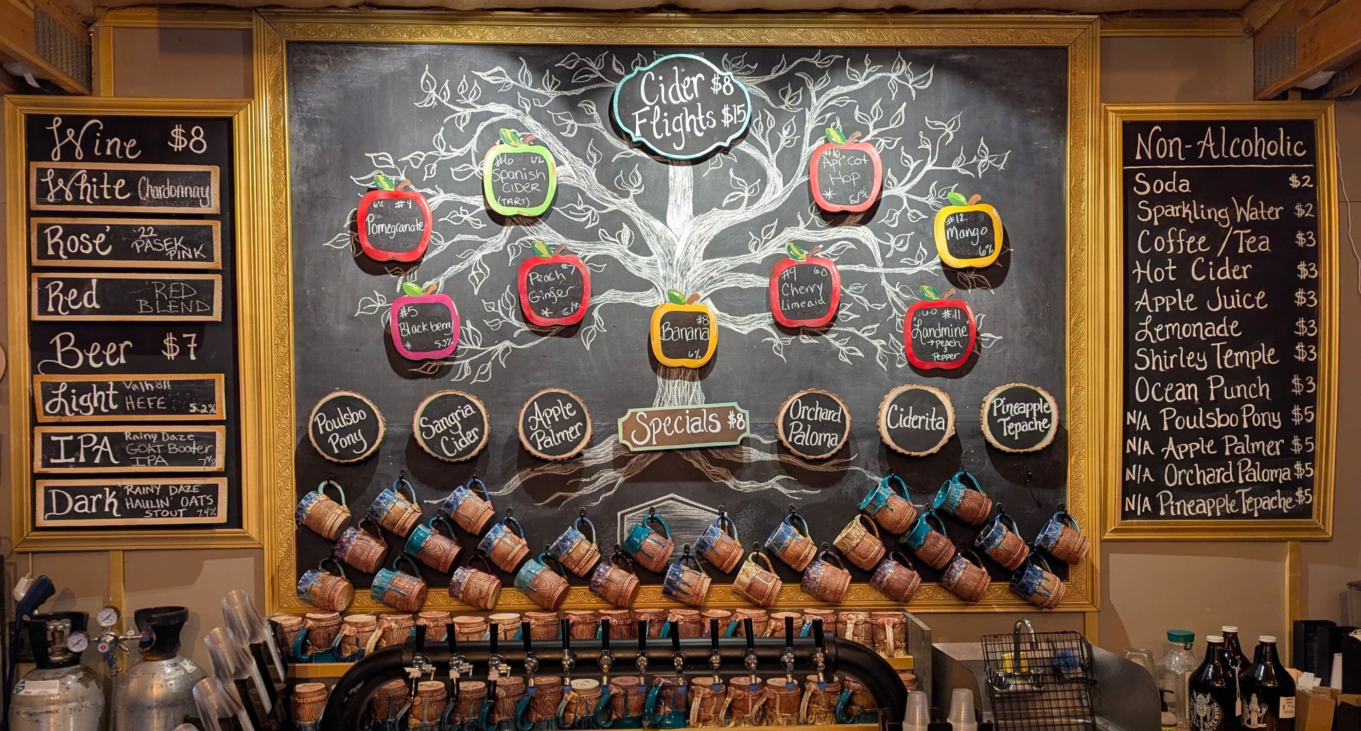 Rustic cider bar menu featuring cider flights, craft beer, and wine listed on chalkboard signs.