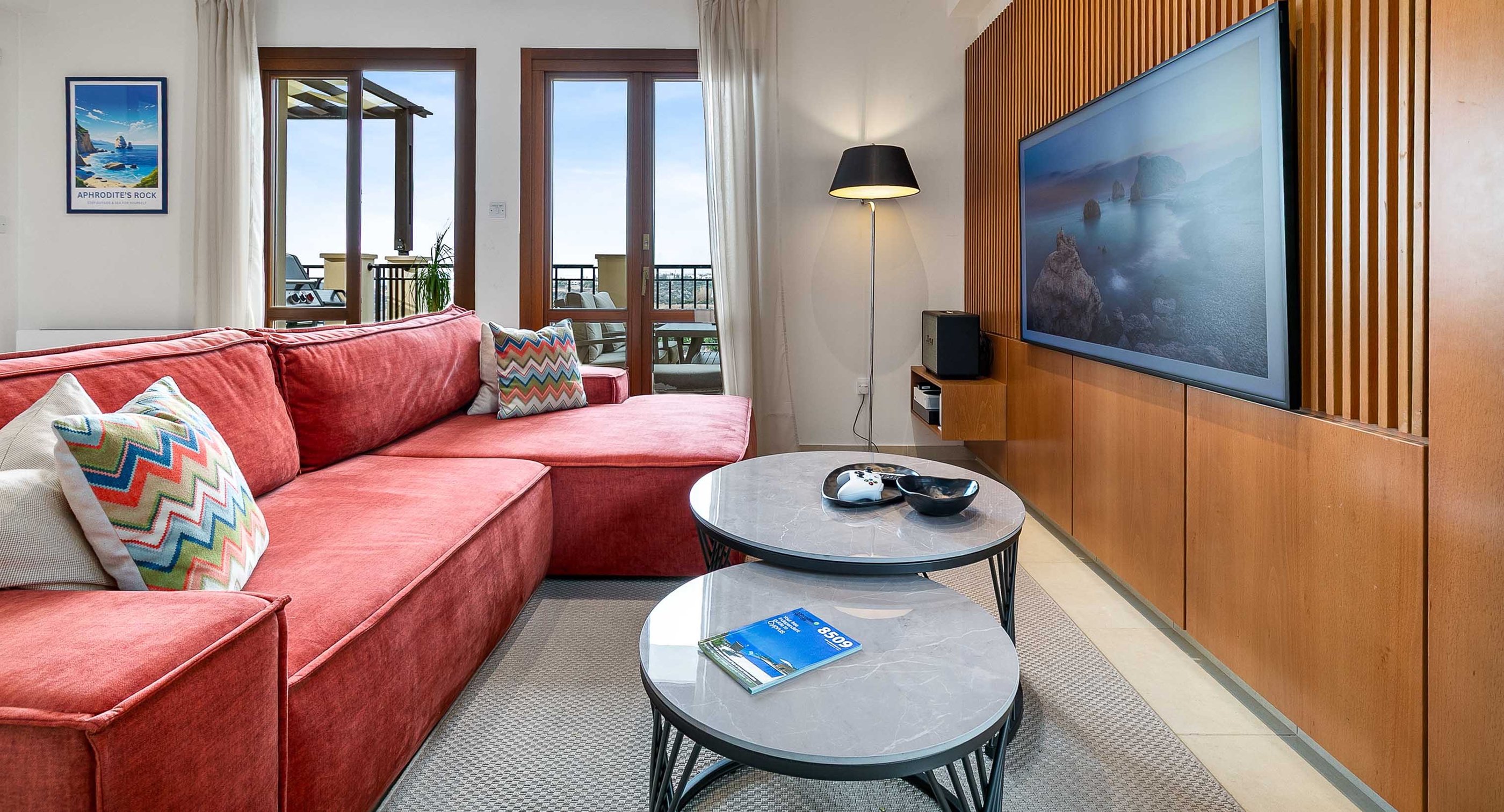 Living room seating area with large TV and sea view at Theseus Retreat holiday rental