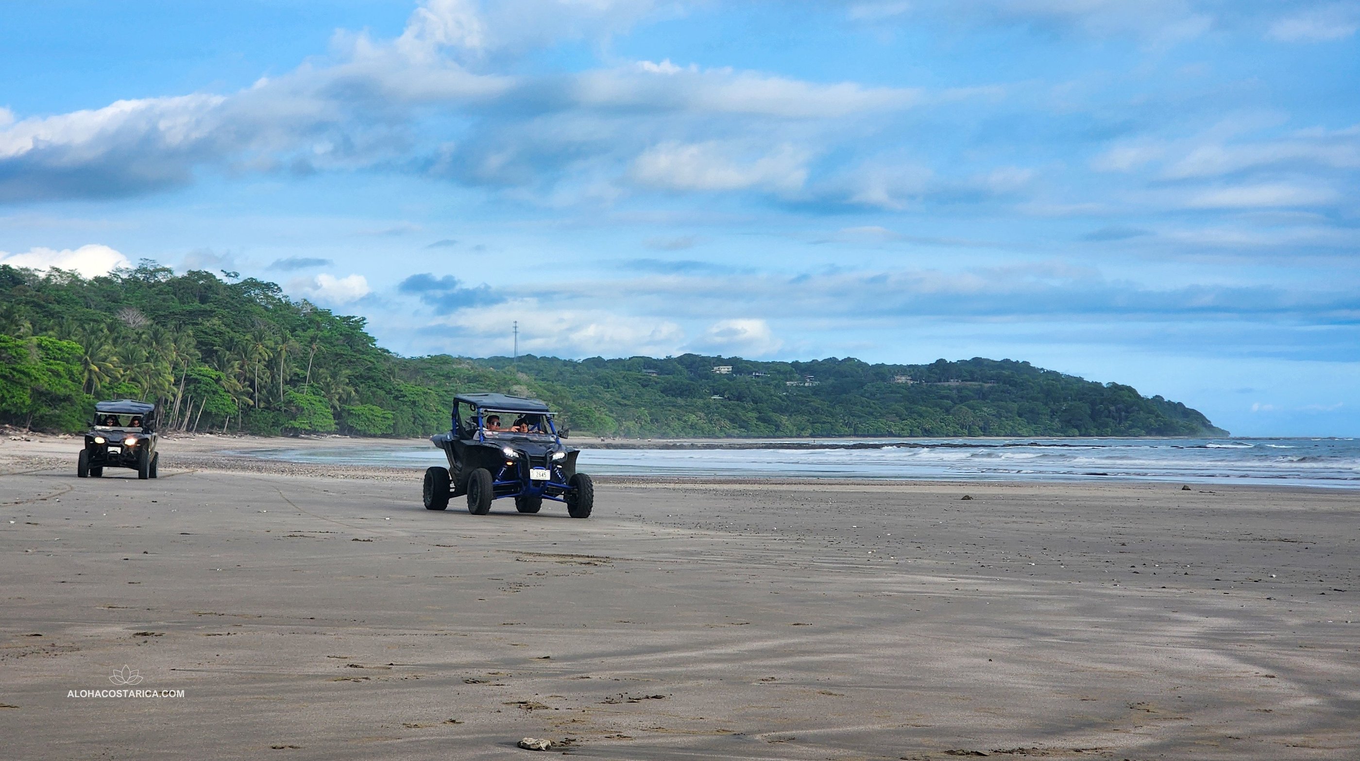 two people riding atvs on a beach