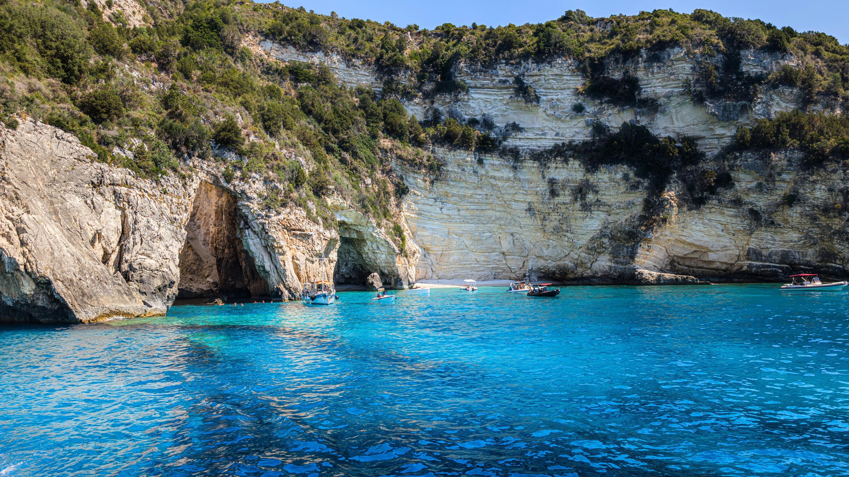 a boat in the water near a cliff