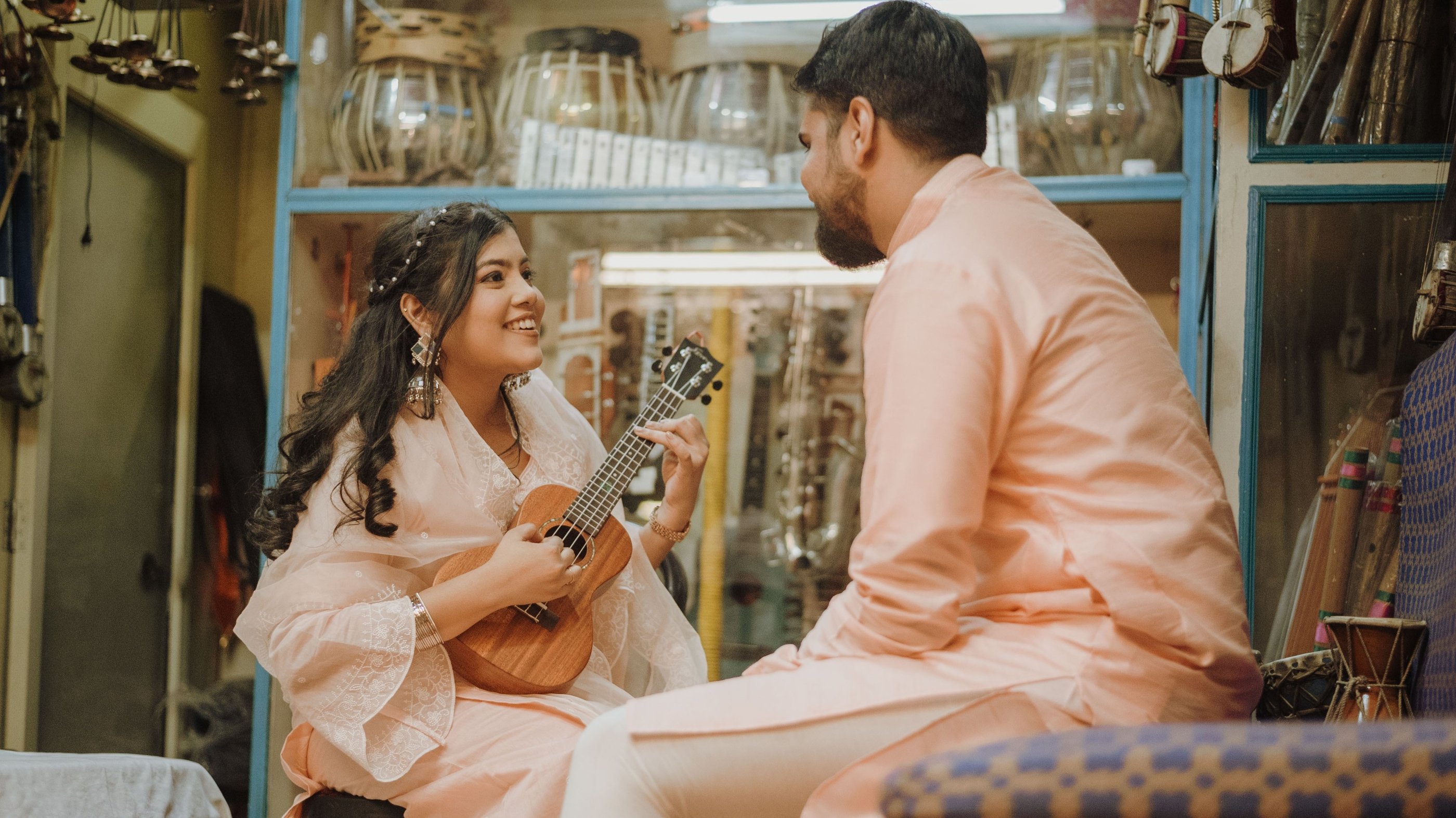 a man and woman playing guitar together