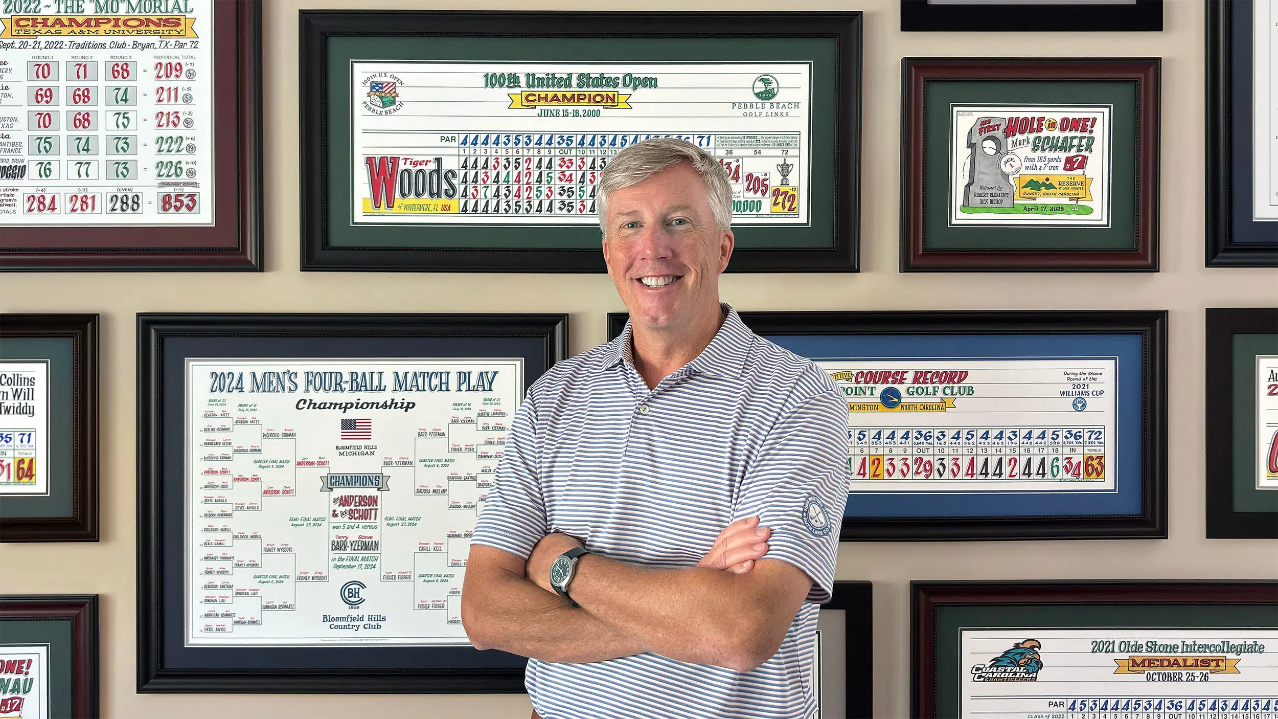 Casey standing in front of a wall of his colorful golf artwork.