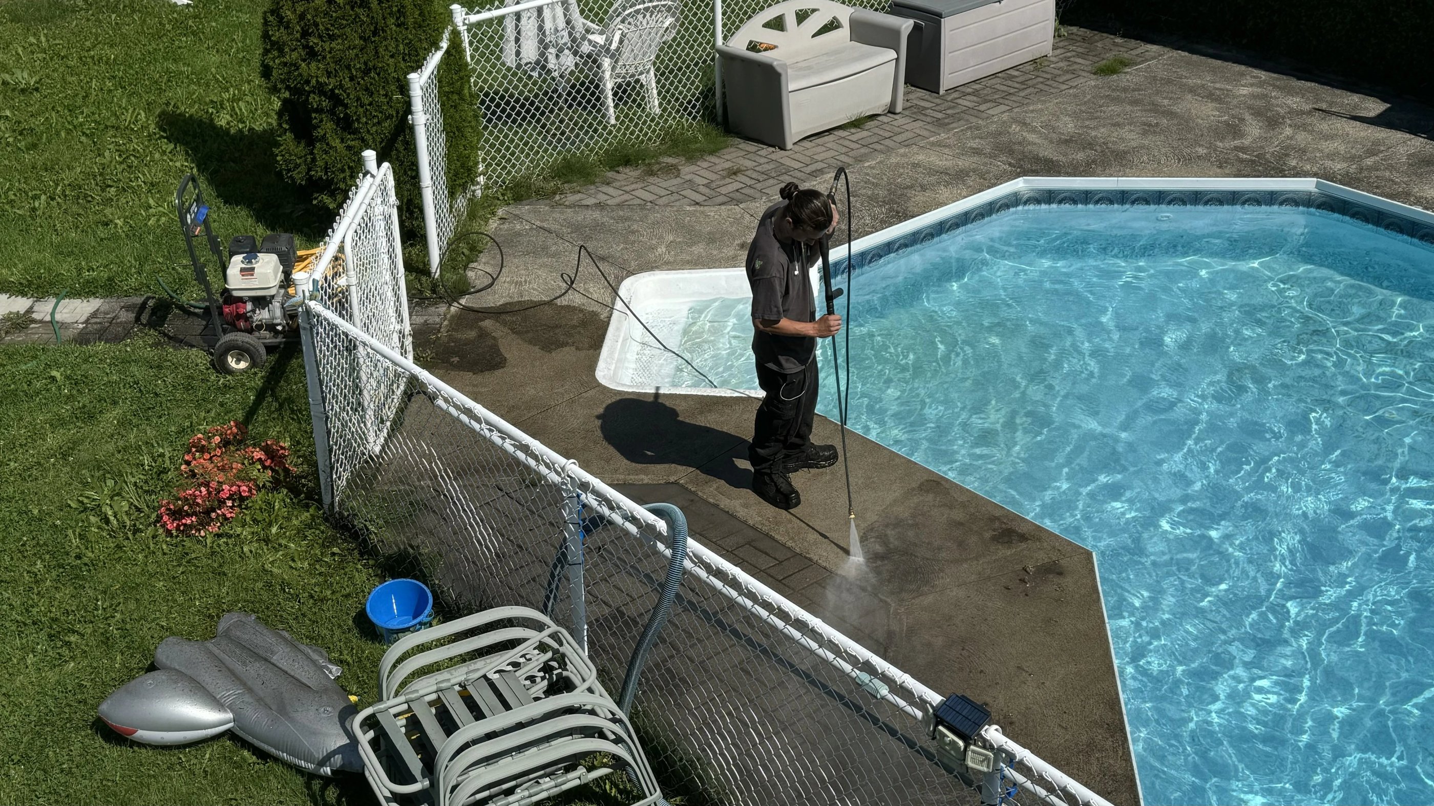 a man is pressure washing a concrete in a backyard