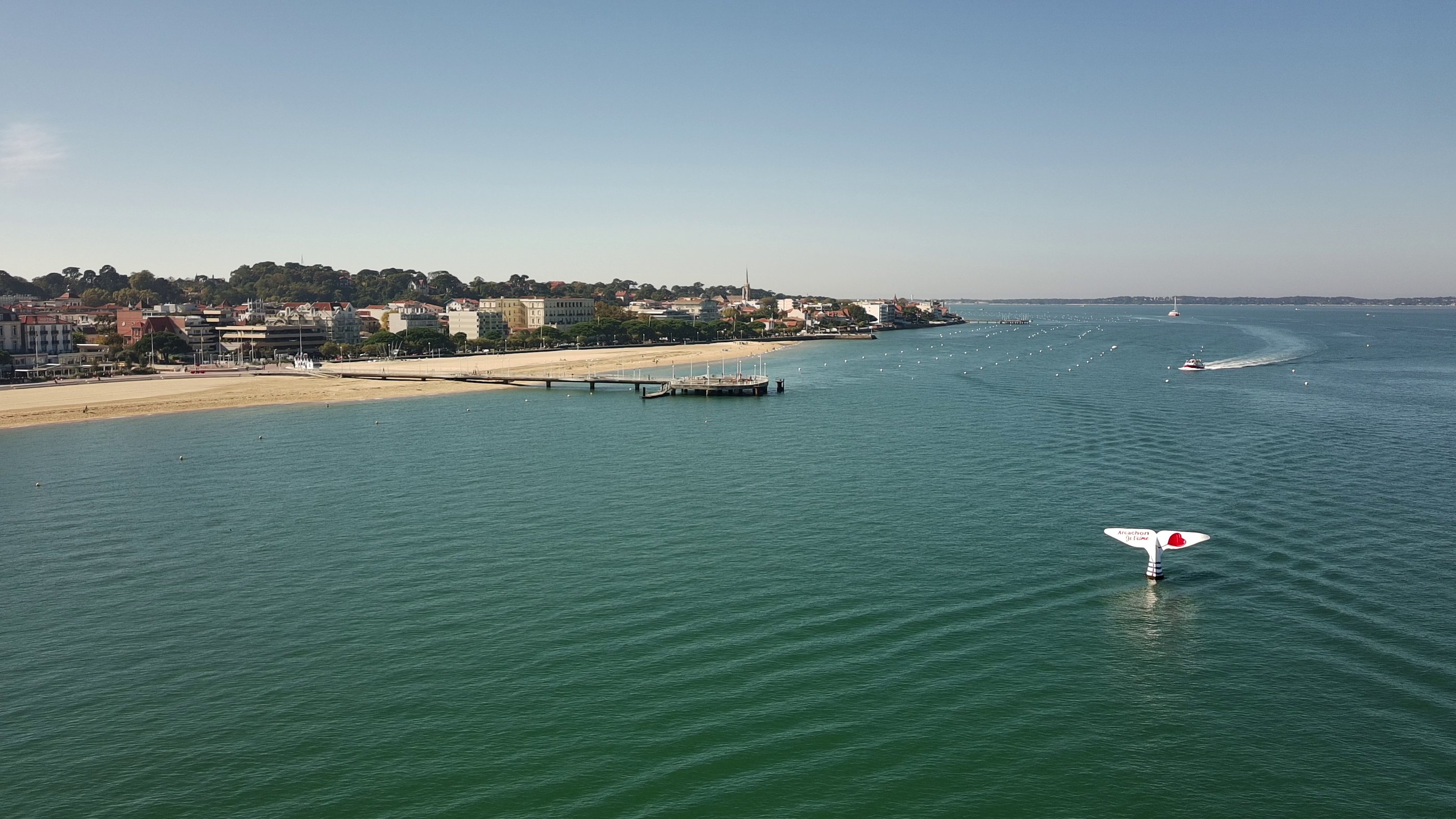 Vue aérienne de la plage d'Arcachon et de l'embarcadère avec une queue de baleine blanche