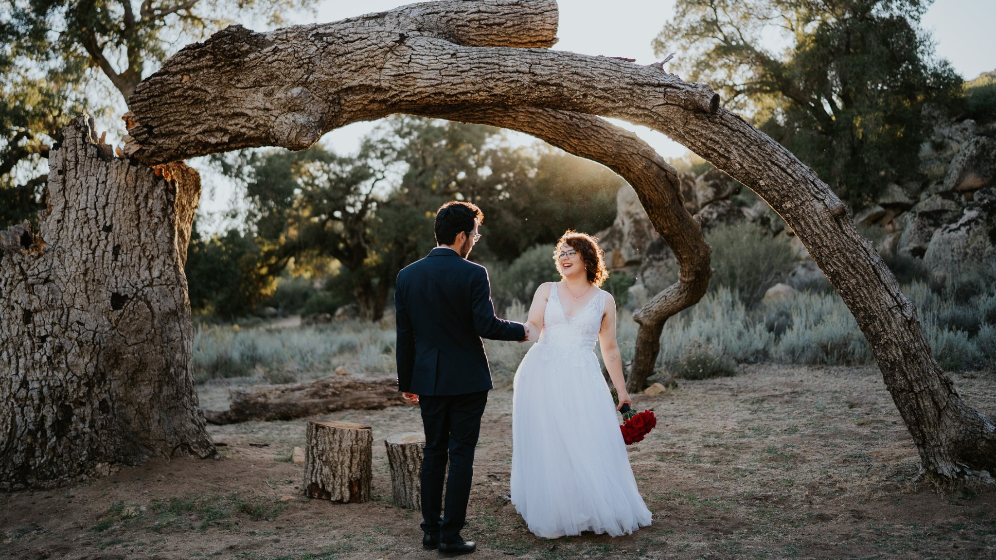 a bride and groom walking down a path in a desert