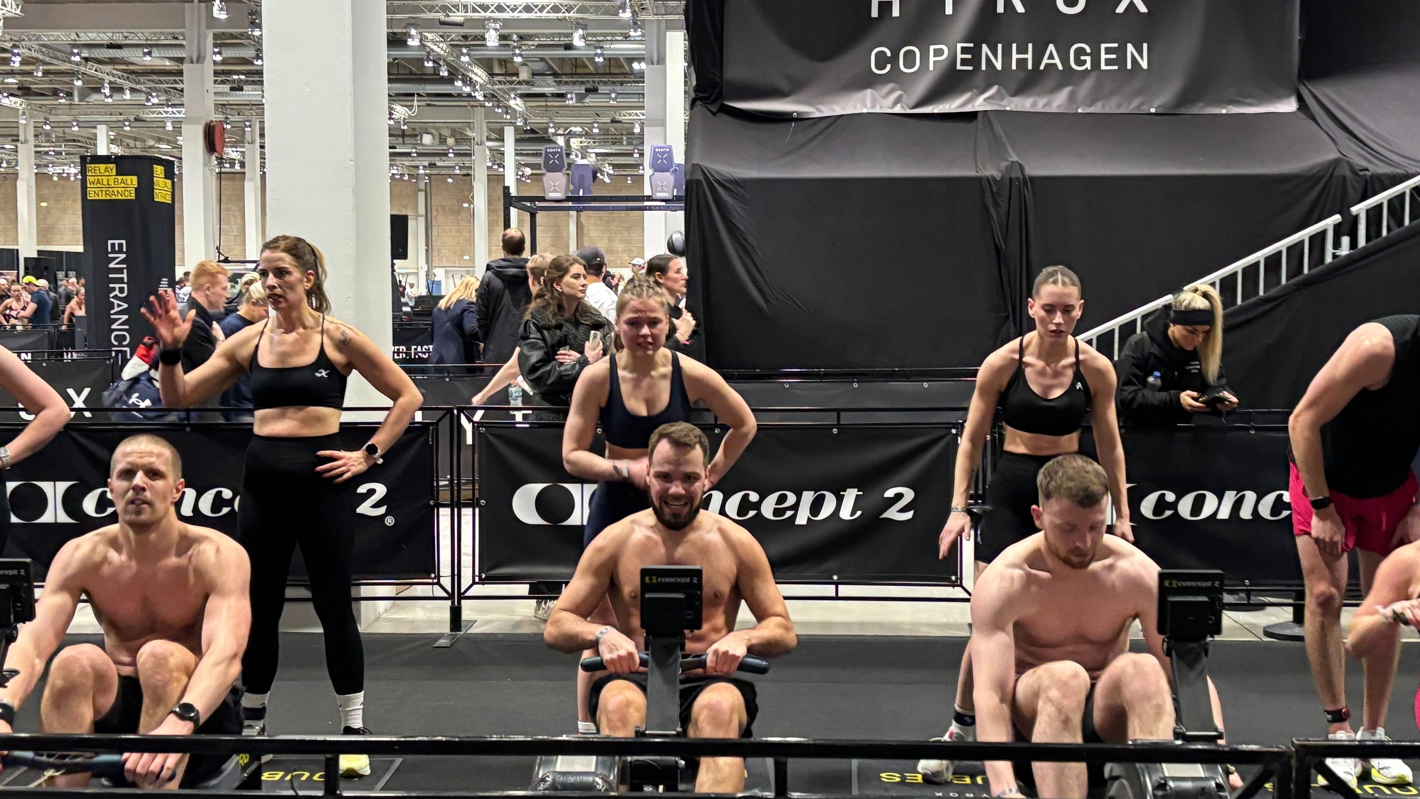 Arena shot – bright lights, crowds, athletes rowing