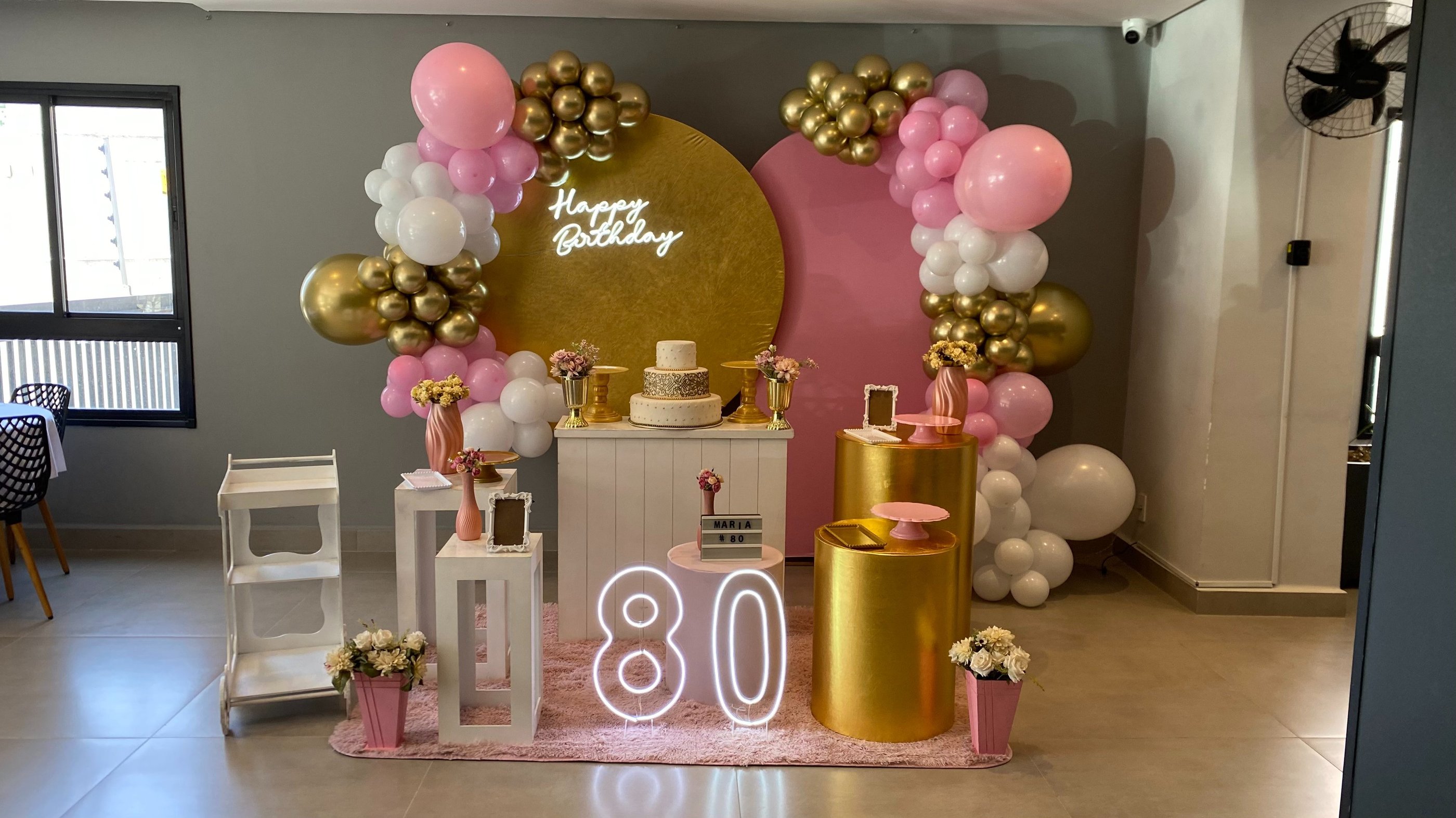 Decoração 80 anos rosa e dourado com arco de balões, painel elegante e mesa decorada Freguesia do Ó