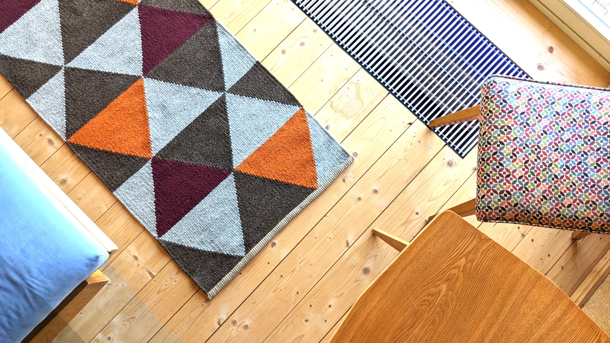 Modern handwoven kilim rug with geometric triangles in orange, burgundy and brown, adding warmth and