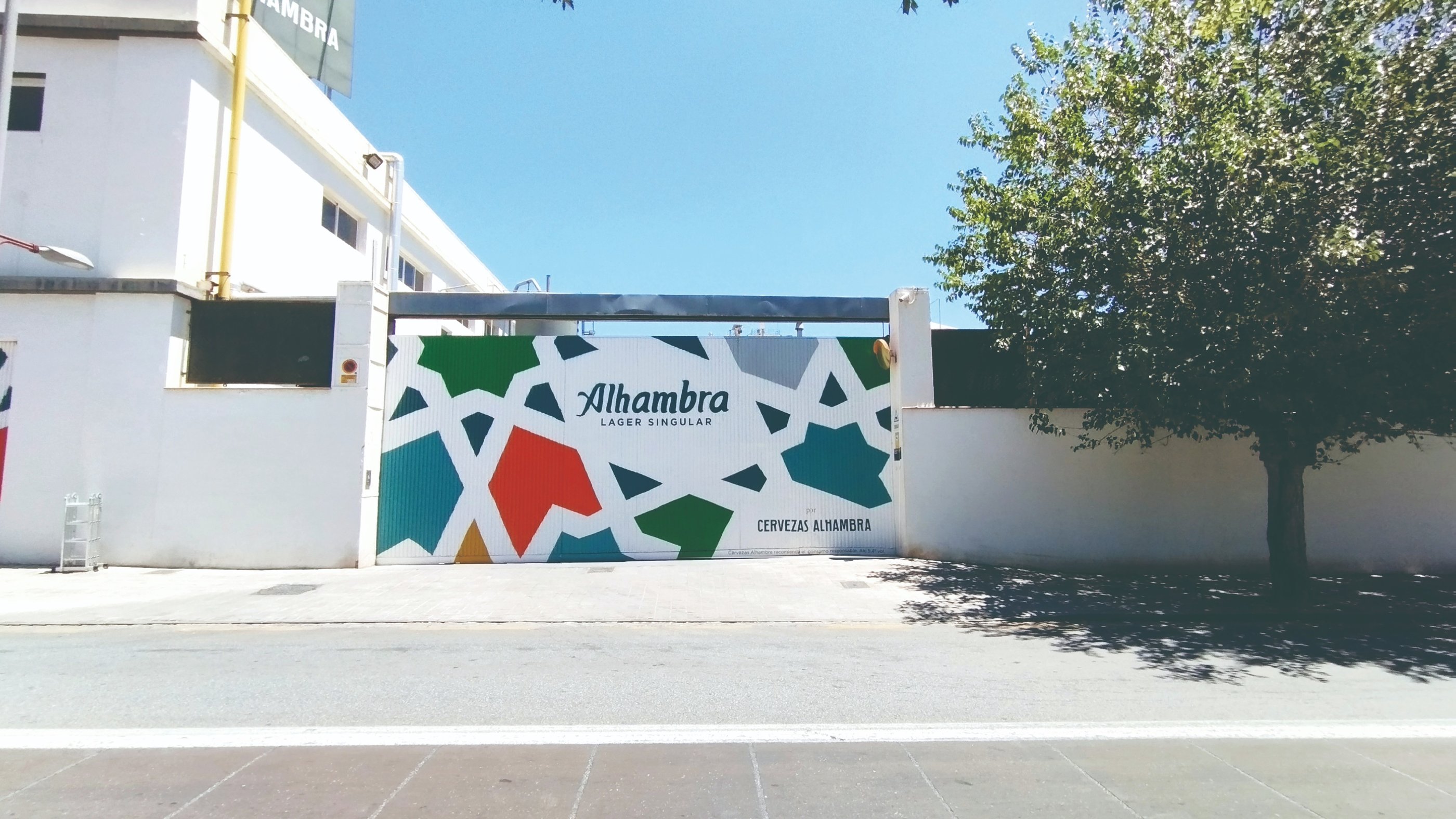 Graffiti mural corporativo en fachada fábrica Cervezas Alhambra. Para la campaña de Grupo Mahou.