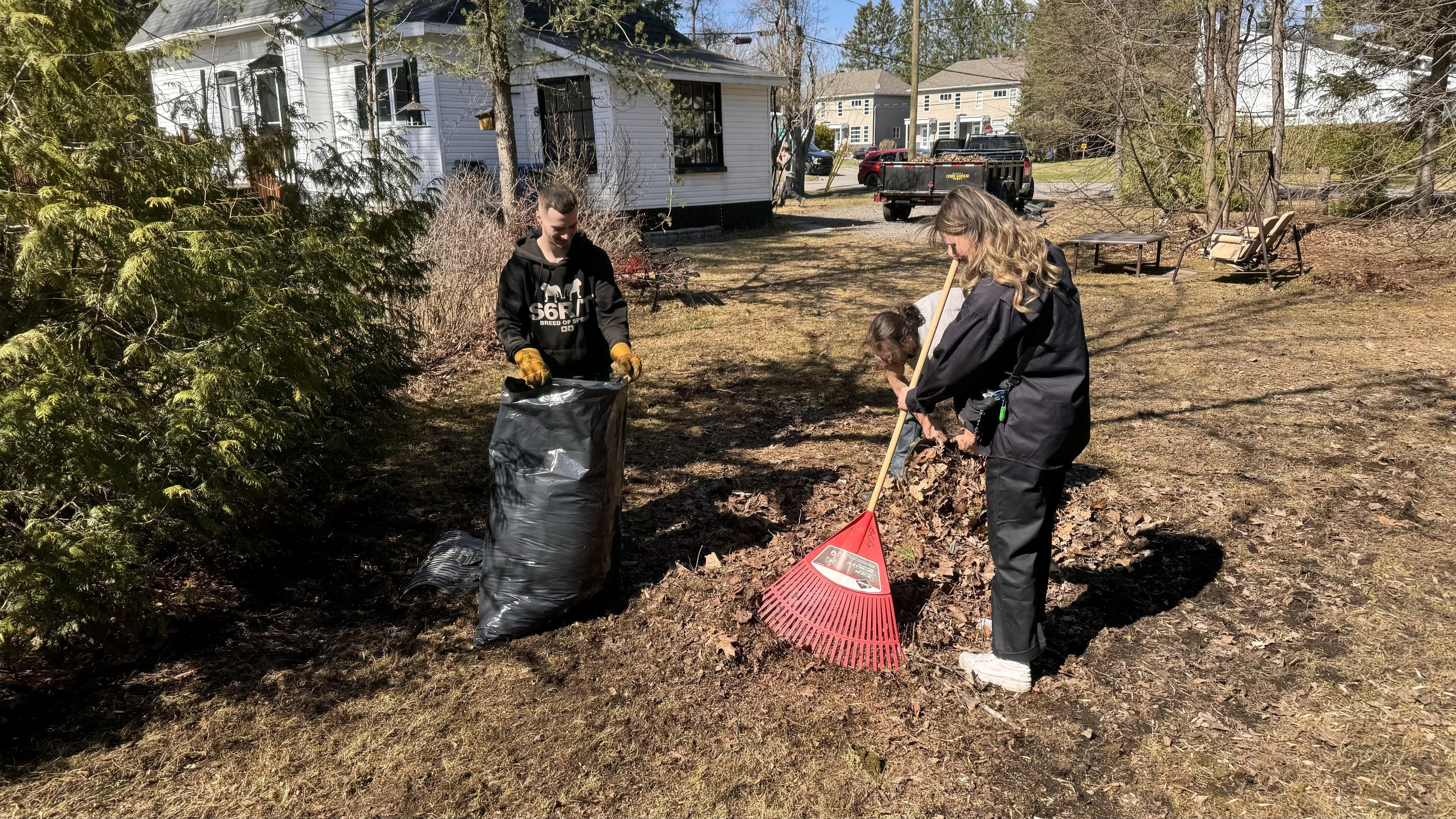 employees raking leaves with gcg truck in the backround