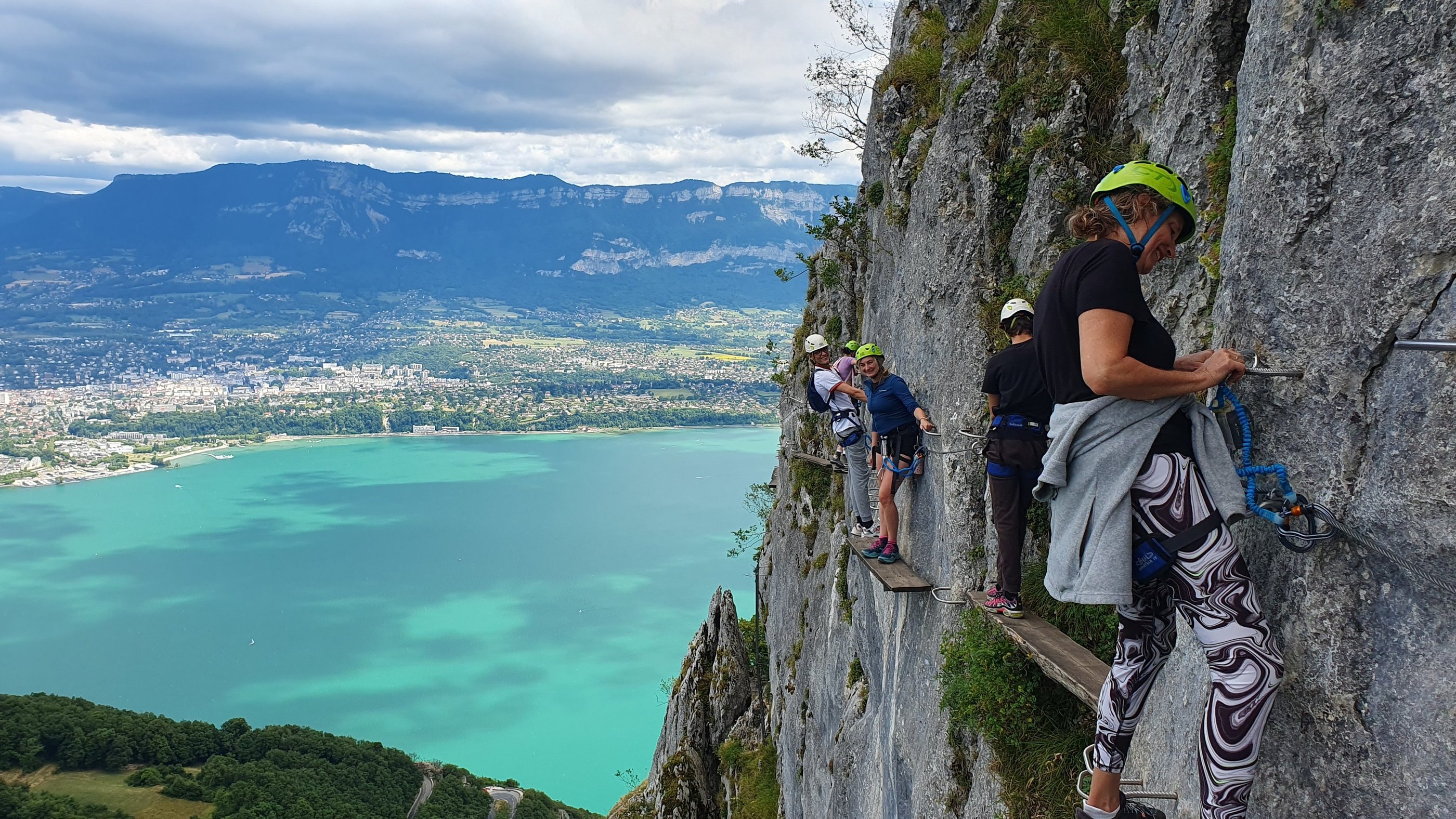 Personnes sur une planche étroite surplombant le lac du Bourget dans la via ferrata du Cornillon