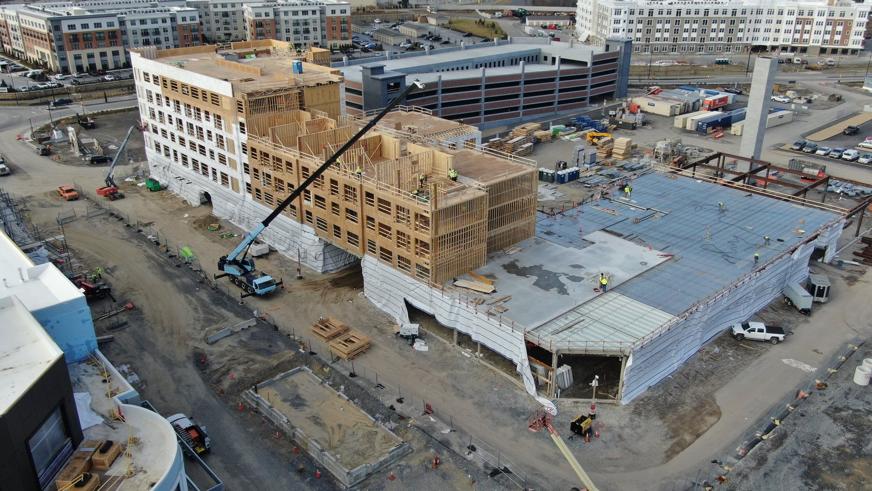 a large Wood Paneling Frame building with a crane in the foreground