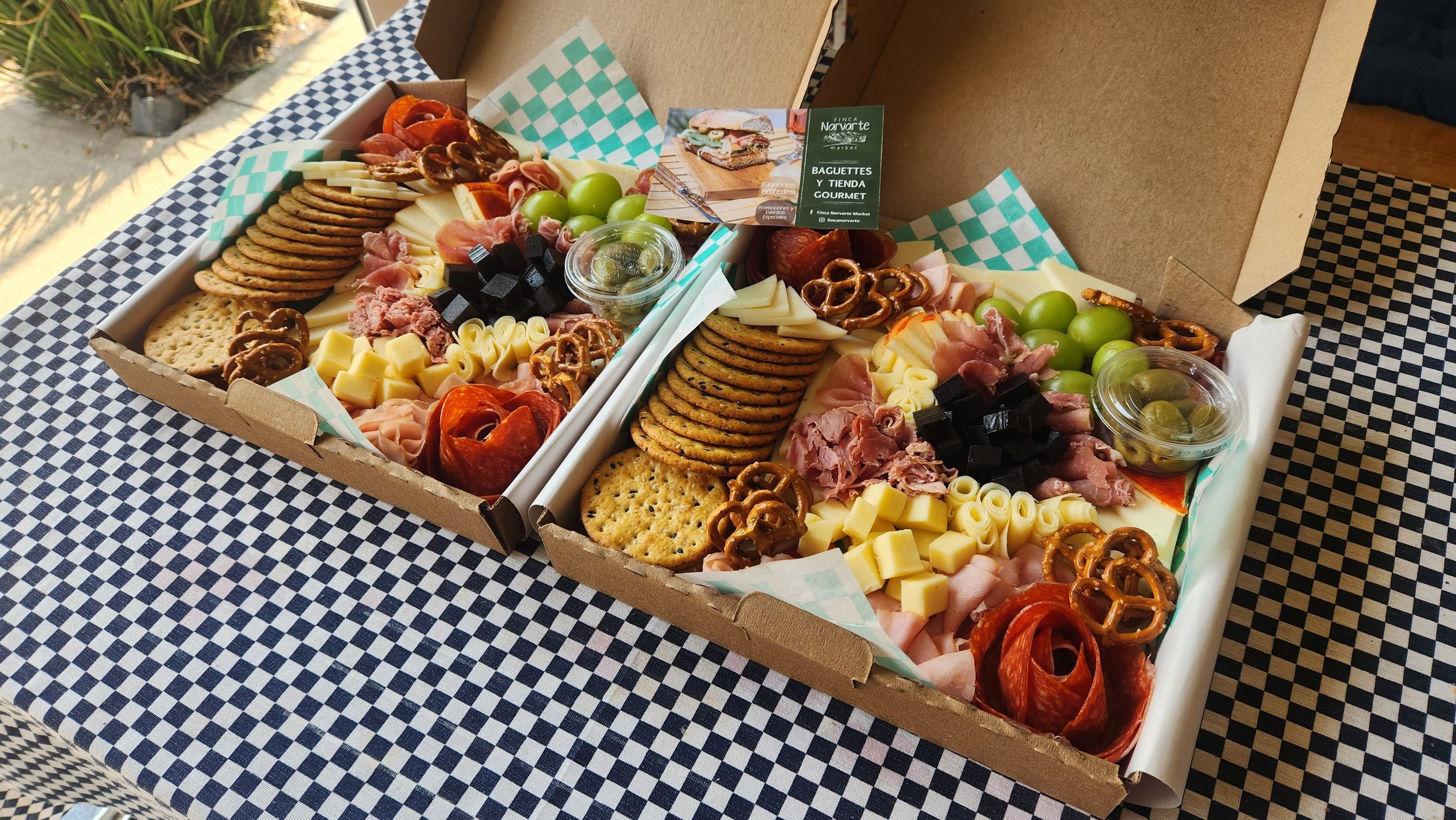Gourmet charcuterie grazing boxes with artisan meats, cheeses, crackers, and grapes for catering.