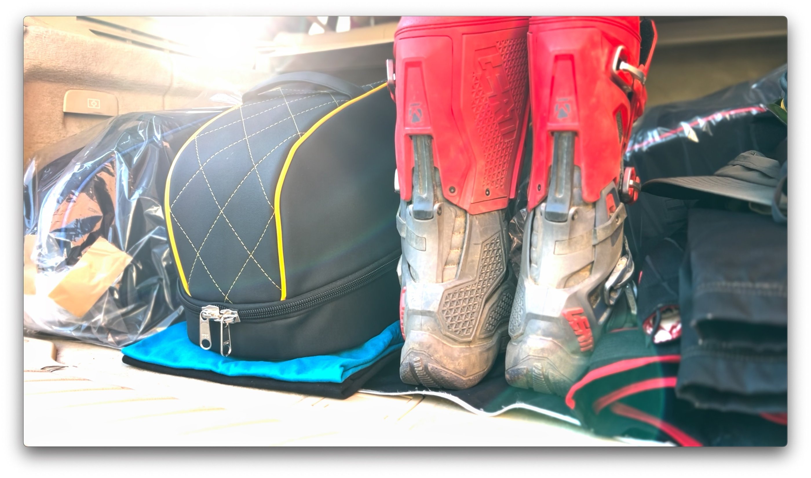 a pair of mx boots and a luxury helmet bag