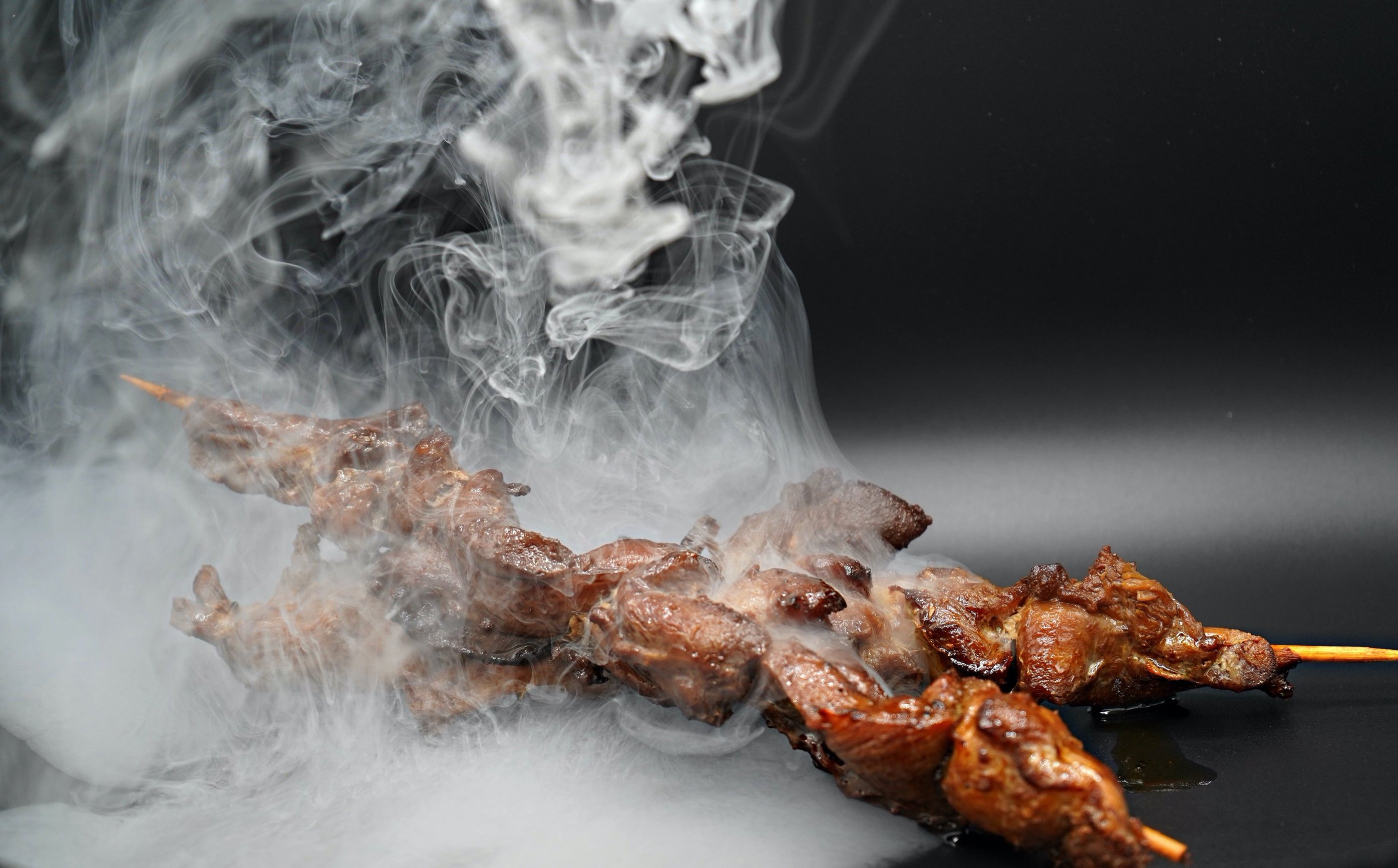 Teryaki Chicken Kabobs with smoke from the grill around the kabobs making it look tasty