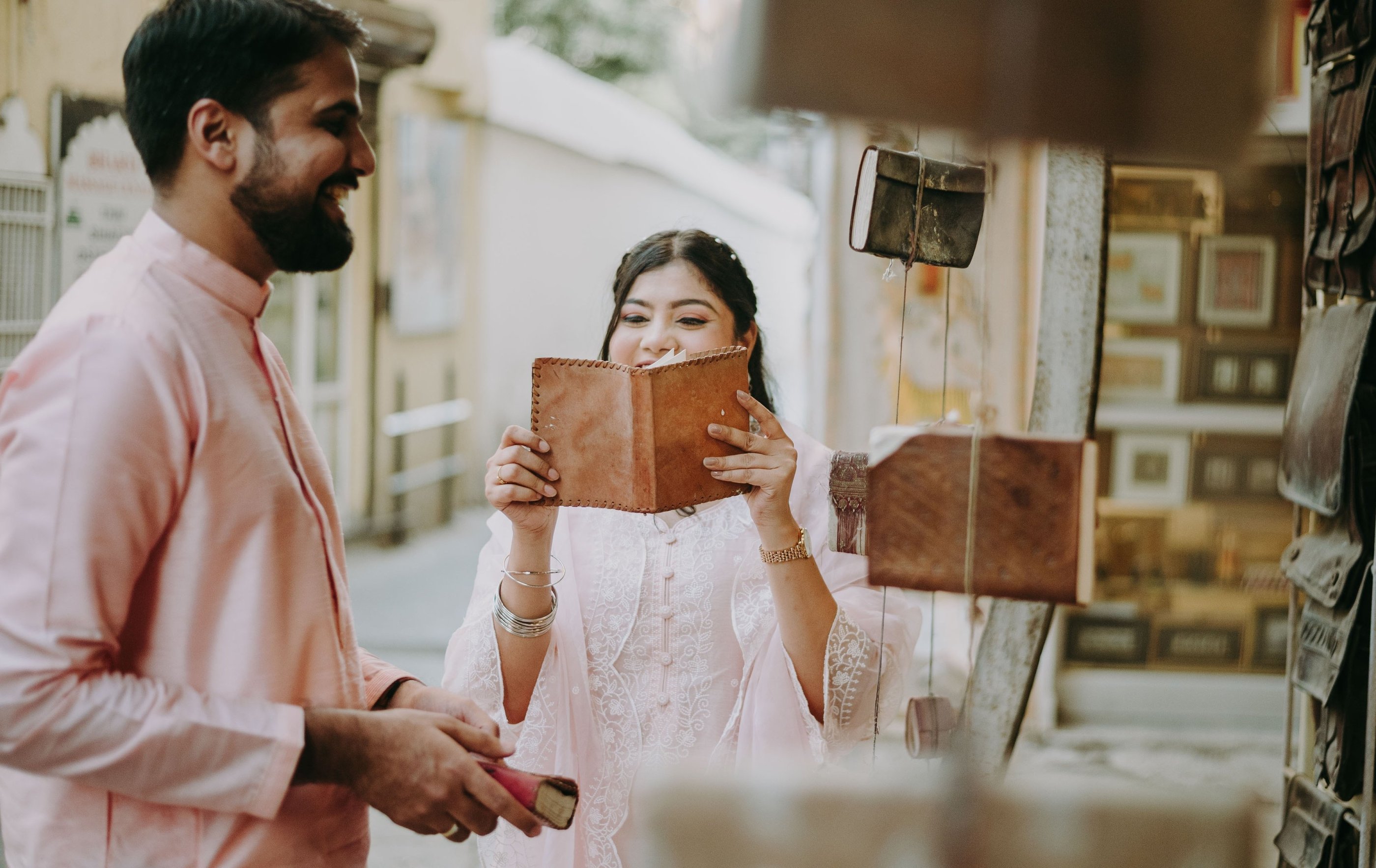 a man and woman in the streets of old city, udaipur, reading books
