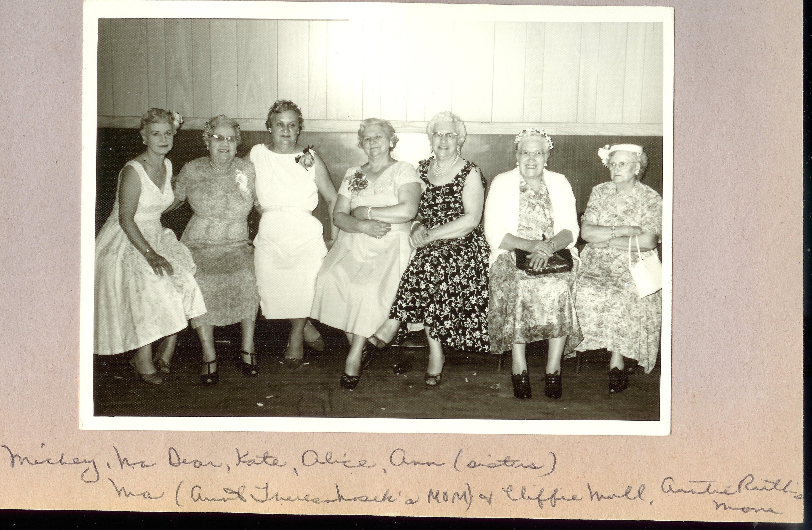 a group of women sitting on a bench in a room