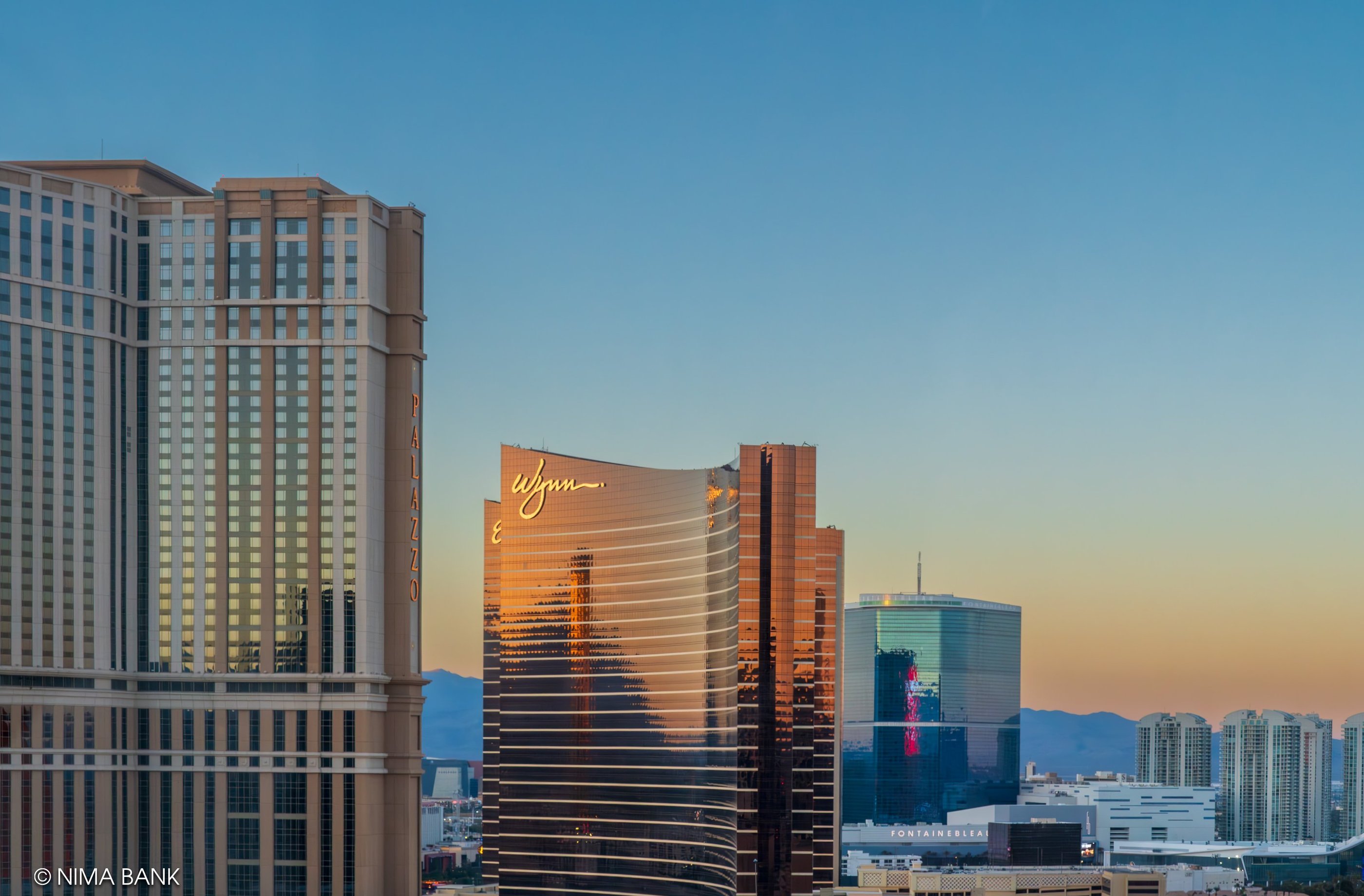 las vegas skyline showing the wynn hotel and a fiery sunset sky