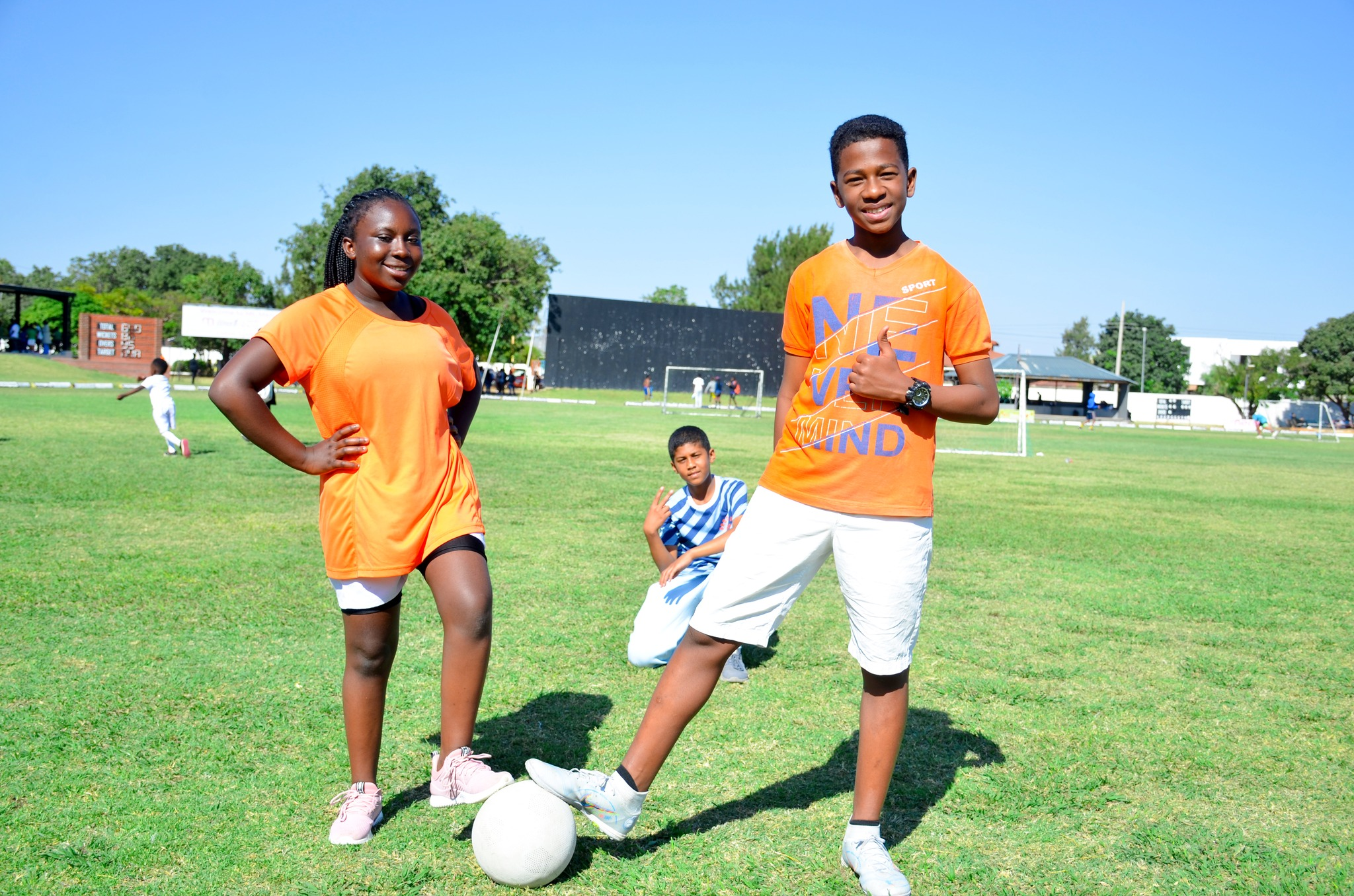two young men playing soccer on a field