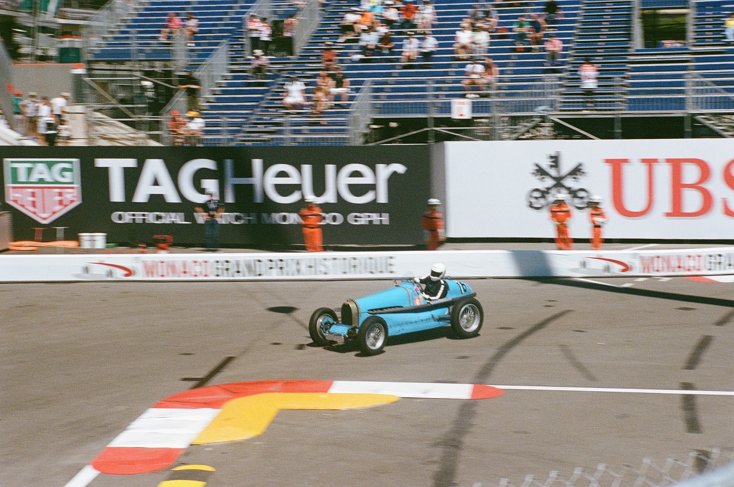 a man driving a blue race car on a track in Monaco