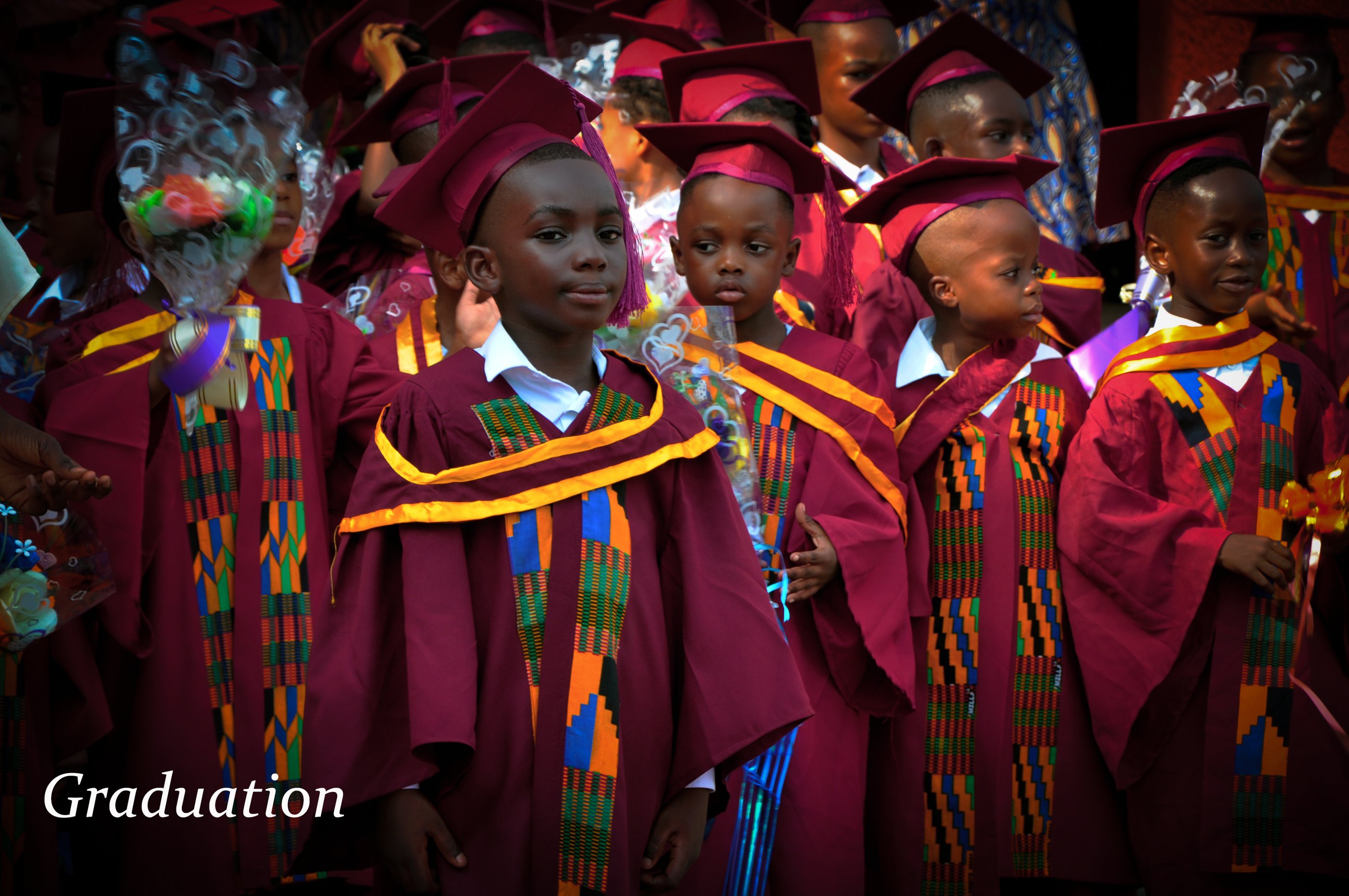 a group of young children in graduation gowns