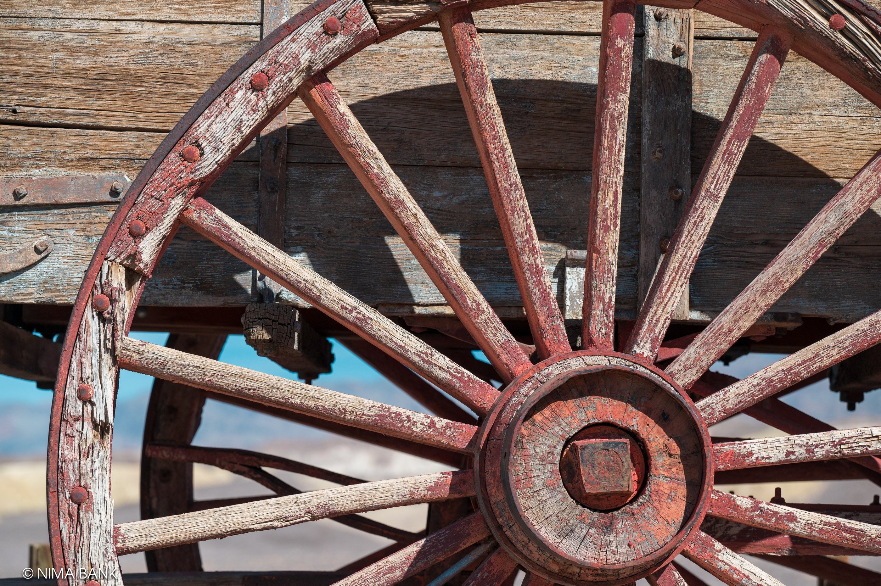 the red spokes of a wooden wagon wheel at harmony borax works in death valley